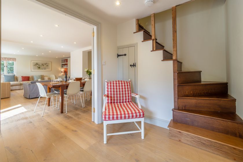 Bright Hallway with Wooden Staircase and Red Chair