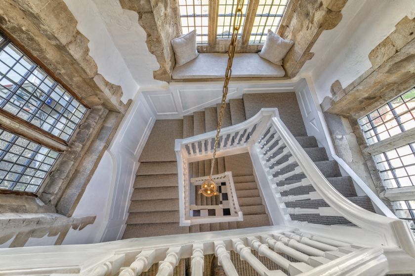 Spiral staircase with white railings and carpeted stairs