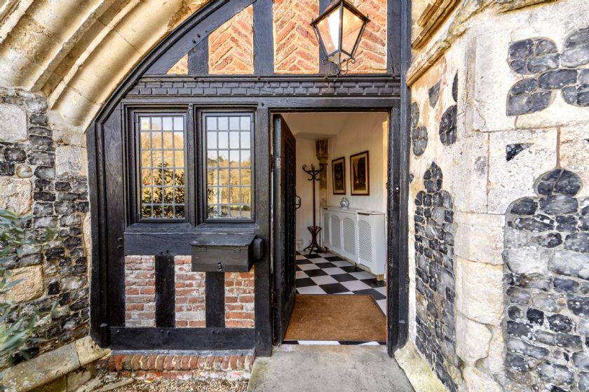 Black timber frame entrance doorway with checkered floor inside