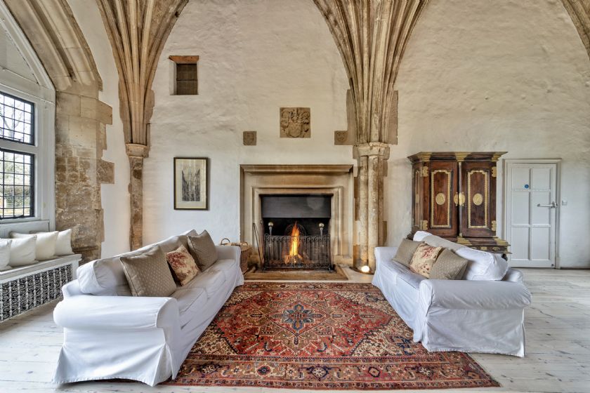 Living room with vaulted ceiling, stone columns and white sofas