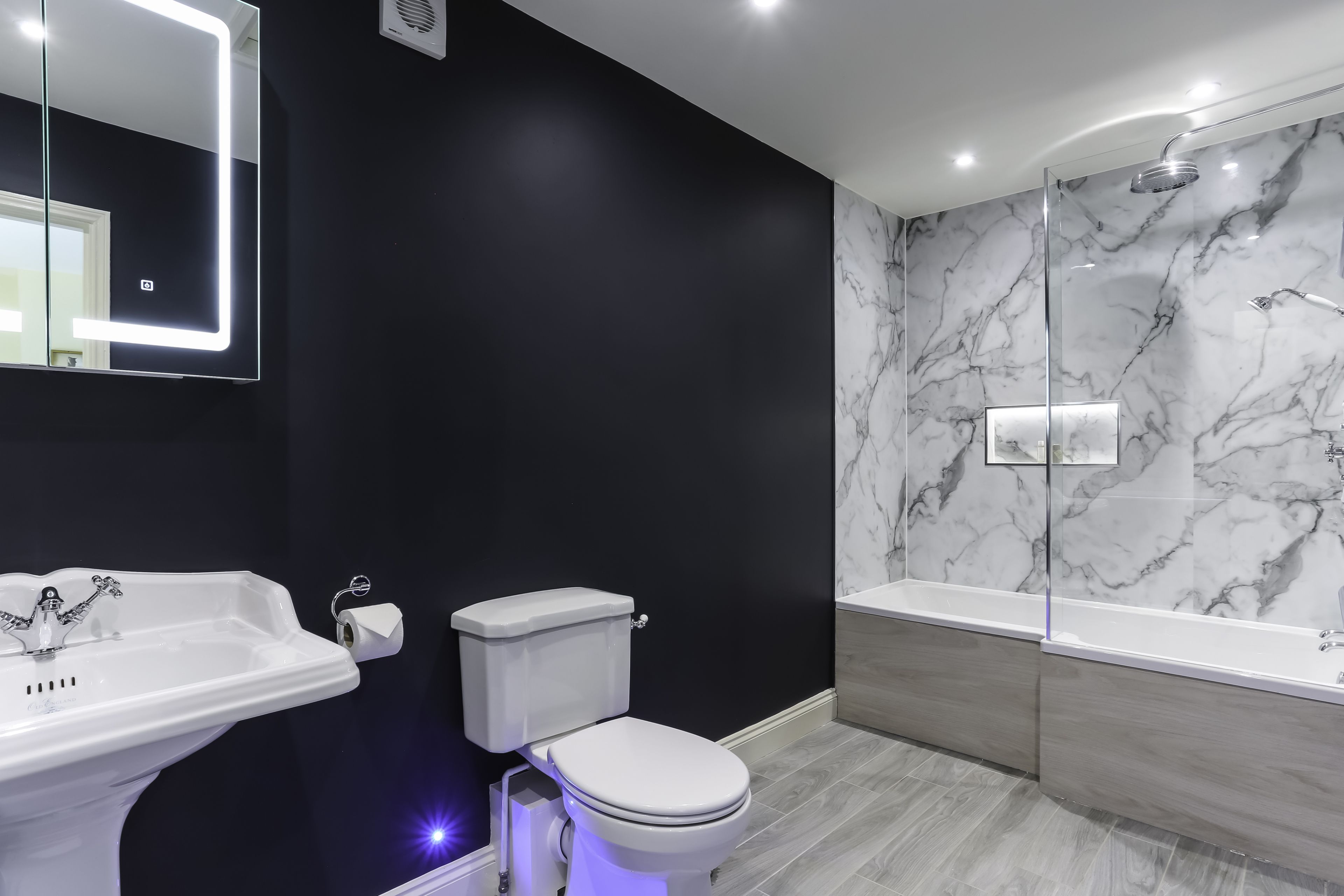 Modern bathroom with black walls and marble-effect shower