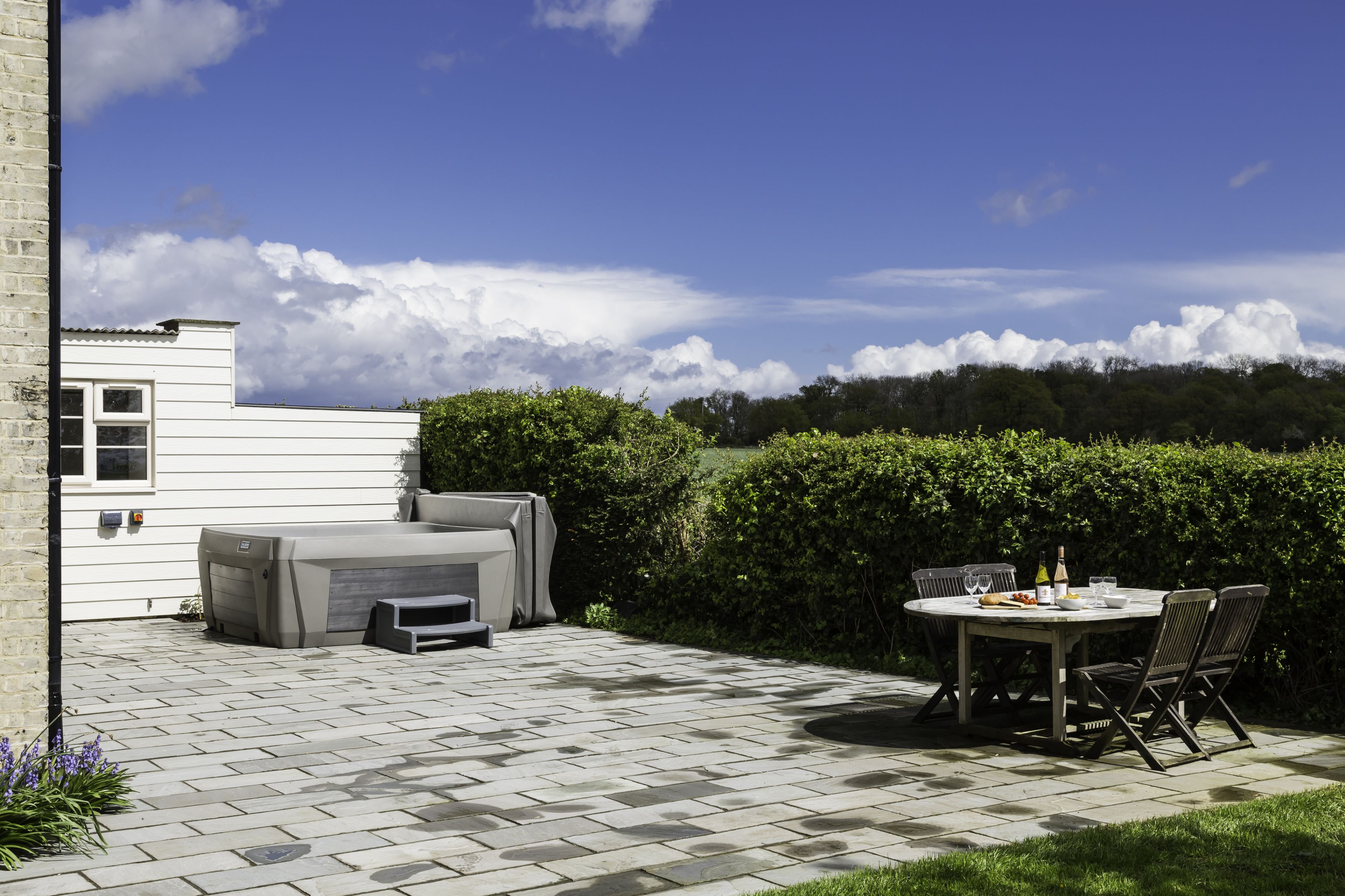 Stone patio with hot tub and outdoor dining