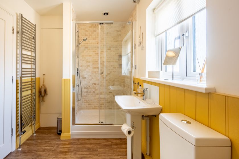 Modern yellow and white bathroom with shower