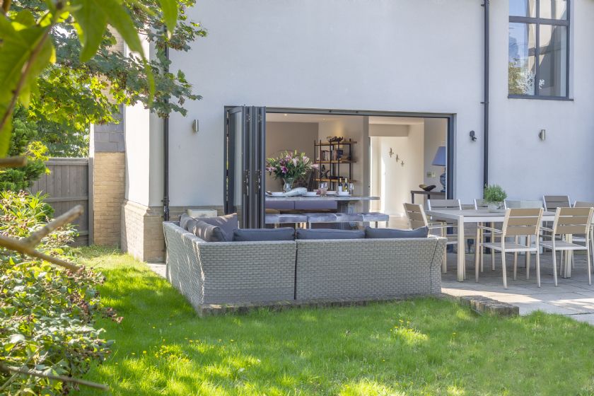Modern garden patio with bi-fold doors and outdoor furniture