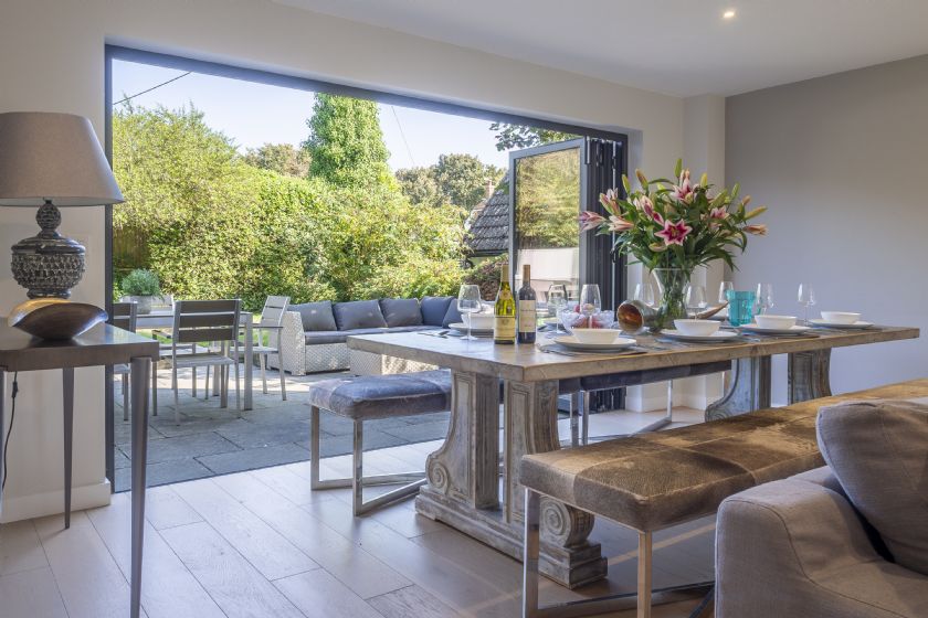 Dining area with rustic table and bi-fold doors to garden