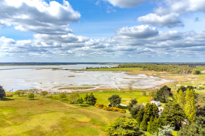 Landscape view of estuary or river with fields and sky