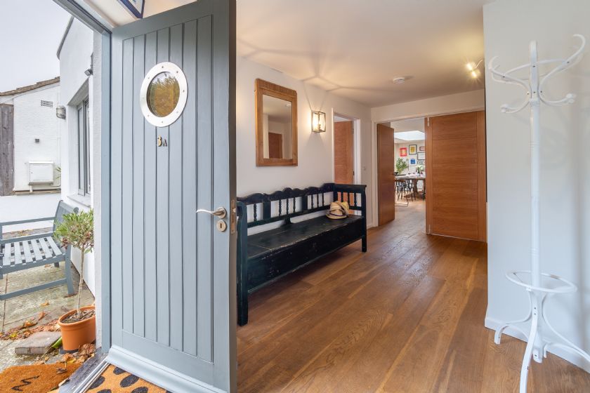 Entrance hallway with wooden floor and black bench