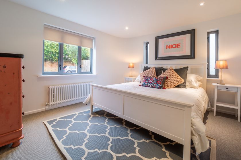 Bedroom with white furniture and blue rug