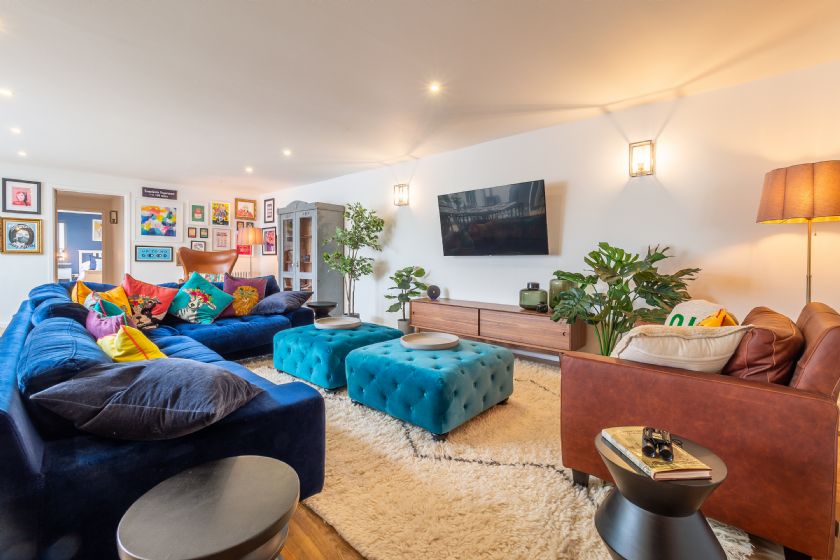 Living room with blue velvet sofa and turquoise ottomans