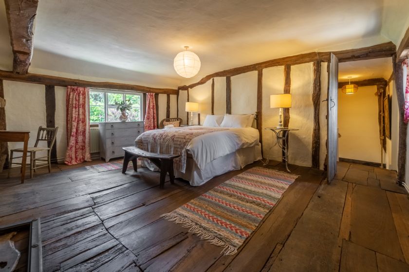 Character bedroom with timber-framed walls and antique furniture