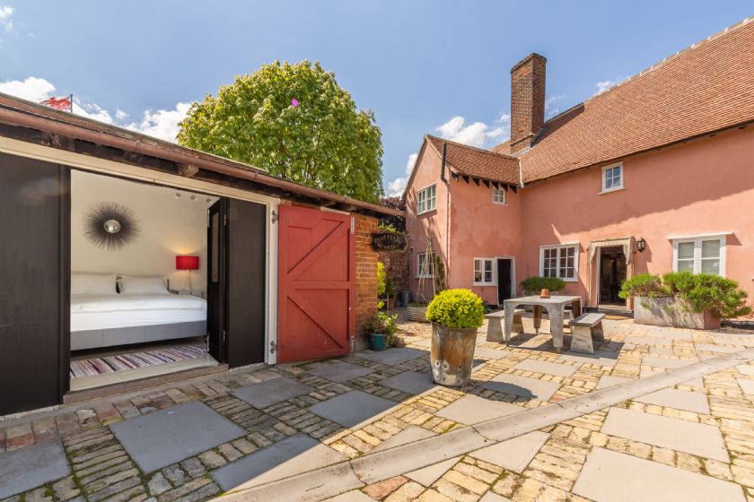 Courtyard with converted barn bedroom and main farmhouse