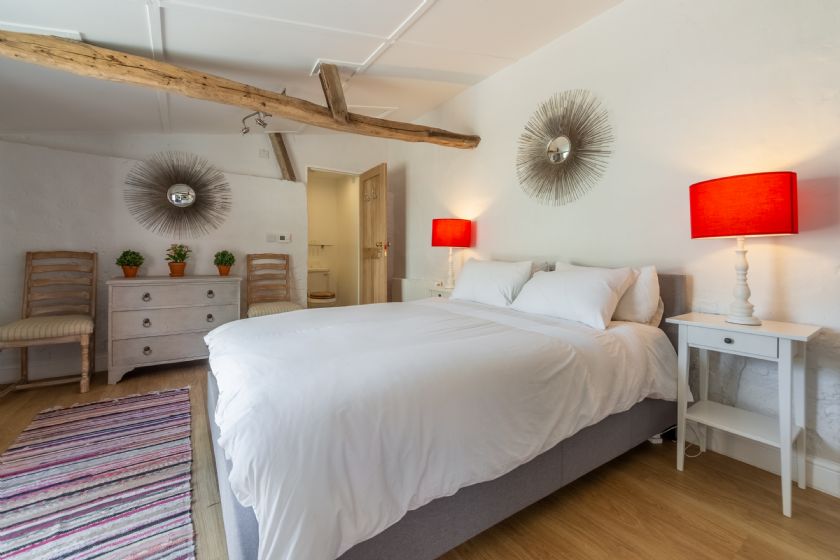 Contemporary bedroom with exposed beam and decorative mirrors
