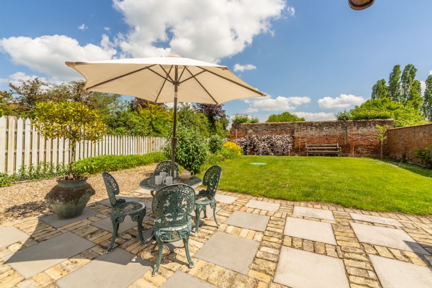 Garden patio with stone pavers and outdoor furniture