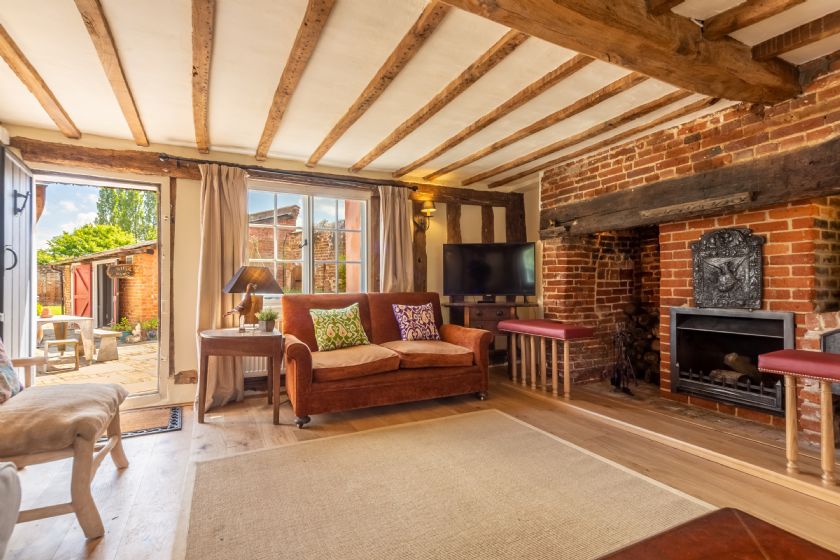 Living room with exposed beams and brick fireplace