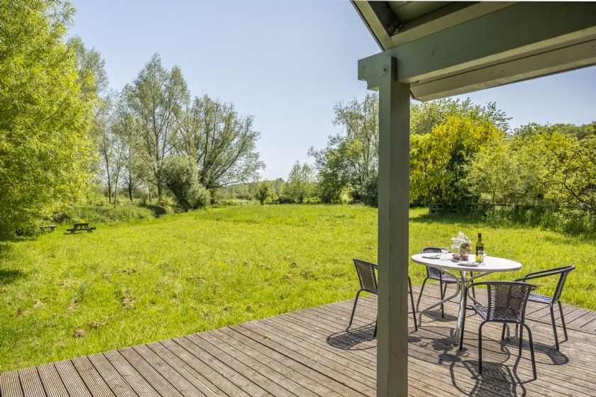 Wooden deck with dining set overlooking meadow