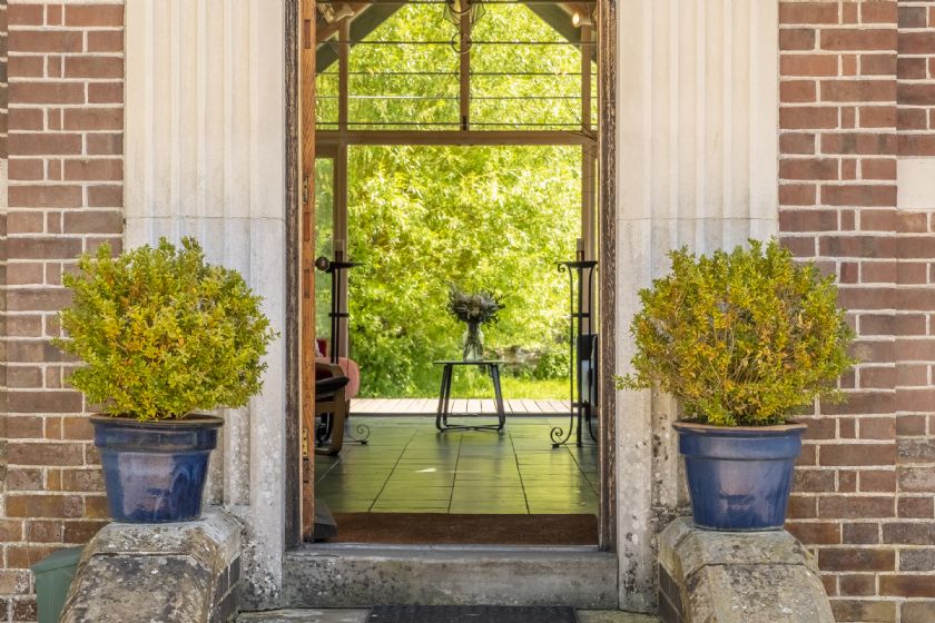 Cottage entrance with brick columns and potted plants
