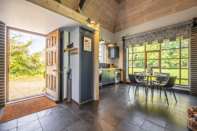 Open-plan kitchen and dining area with wooden ceiling