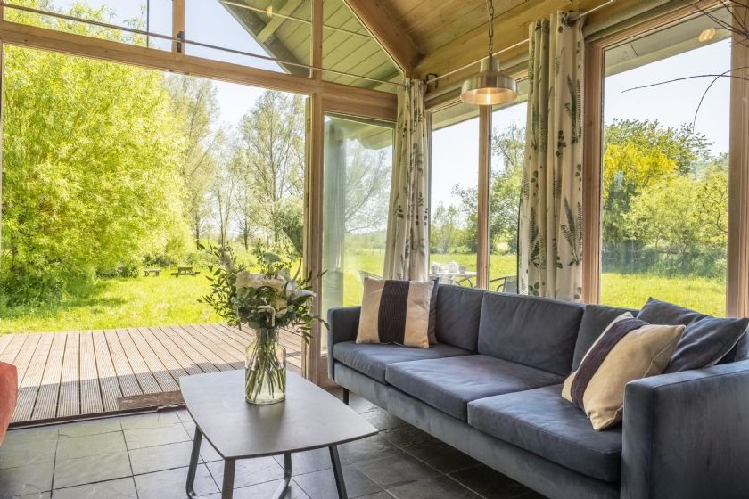 Sunroom with sofas and large glass doors to garden