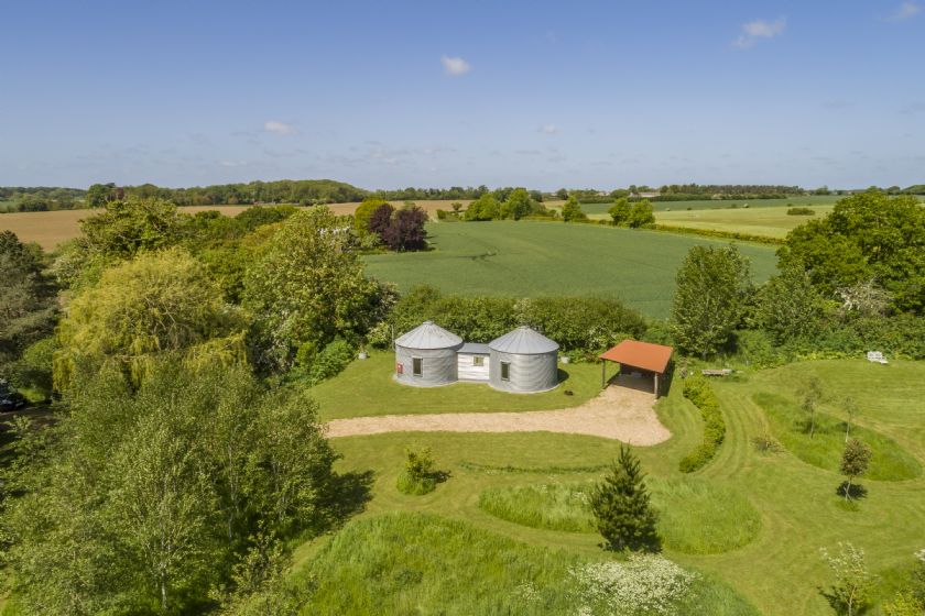 Aerial view of two silo buildings in Suffolk countryside
