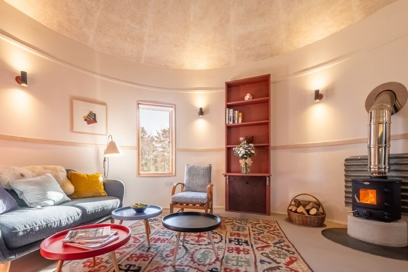Curved interior living room with wood stove and patterned rug