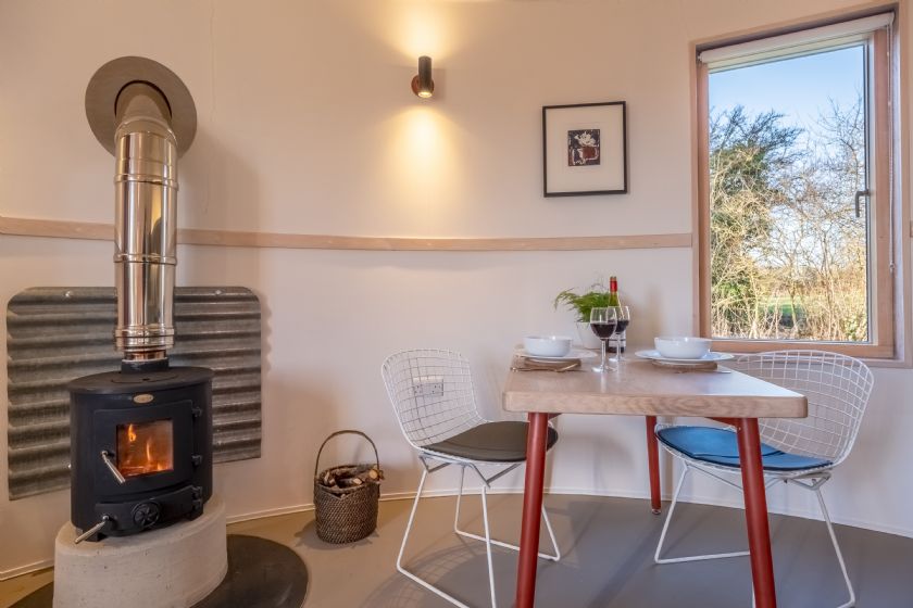 Dining area with wood stove and window view