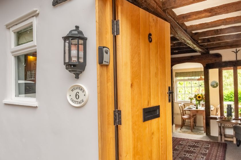 Weaver's Cottage entrance with wooden door and cottage sign