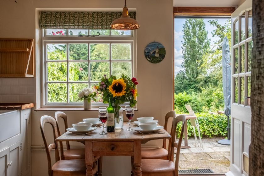 Dining area with table set for meal and garden view