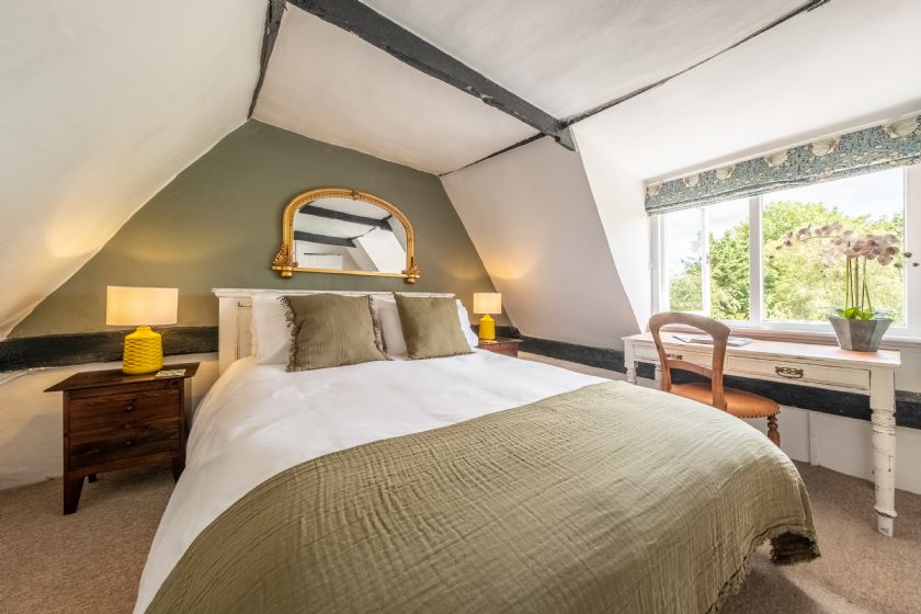 Bedroom with writing desk and garden views