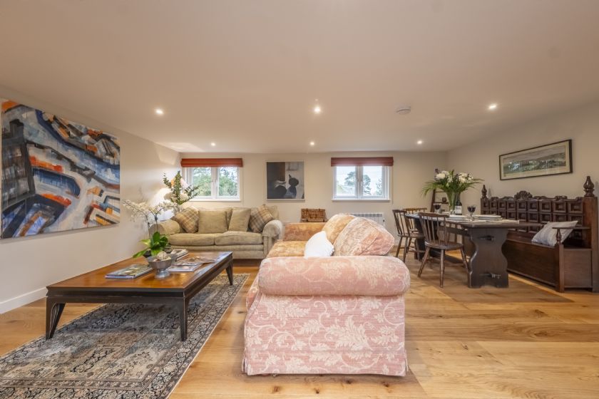 Spacious open-plan living area with sofas and dining table