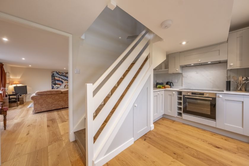 Modern kitchen with stairs and view to living area